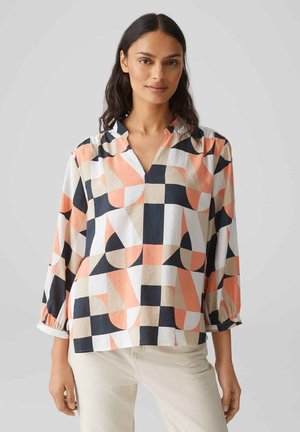 Blusa a maniche lunghe con scollo a V in bianco, blu navy, pesca e beige con motivo geometrico; presenta maniche arricciate e una vestibilità rilassata.