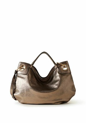 Sac à main en cuir bronze brillant avec poignées courtes, grands œillets dorés sur les côtés et bandoulière amovible sur fond blanc.