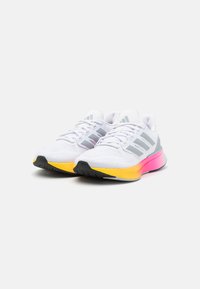 Scarpe da corsa bianche con accenti grigi, tomaia in tessuto texture e suola sfumata con transizione di colore dal giallo al rosa. Suola nera.