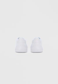 Beli superge z gladkim usnjenim in sintetičnim zgornjim delom, zaobljenim prstom, oblazinjenim ovratnikom in ravnim gumijastim podplatom z minimalnim blagovnim znamčenjem.