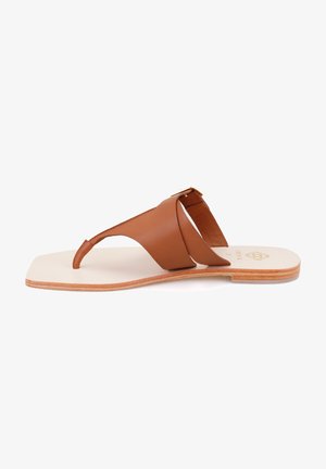 Brown leather thong sandal with crossed straps, flat sole, and a gold-tone buckle detail. Textured footbed and smooth sole edges.