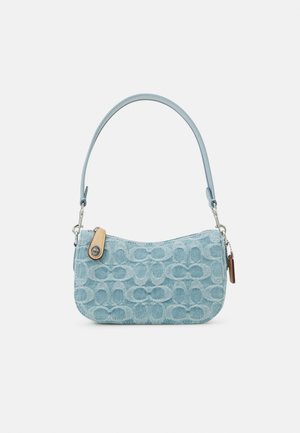 Sac à épaule en denim bleu clair avec motif embossé, languette de fermeture éclair en cuir beige et ferrure argentée sur fond blanc uni.