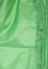 Jasně zelená tkanina s hladkou strukturou. Materiál vypadá lehký a odolný, s jemným leskem. Složené okraje jsou úhledně dokončené.