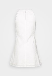 Bílé bezrukávové šaty vyrobené z texturované tkaniny, s vykrojeným silhouette, vysokým výstřihem a zadním zipem s detailem ve tvaru klíčové dírky.