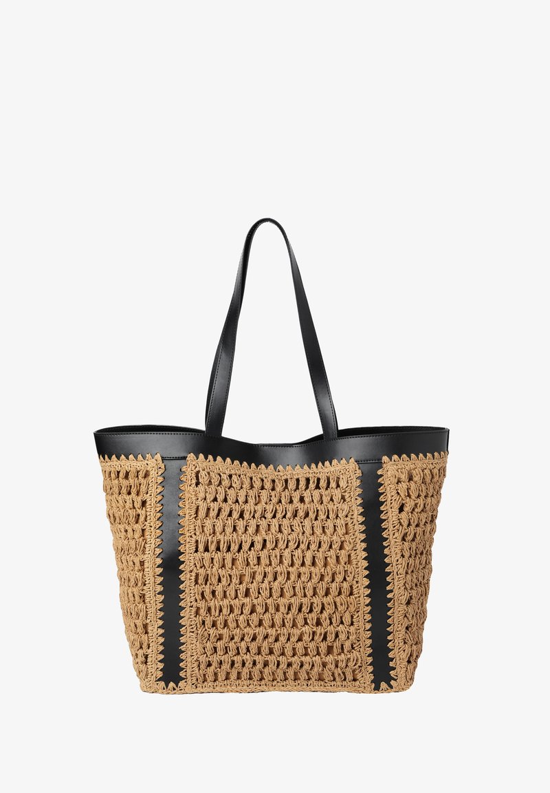 Sac fourre-tout en fibres naturelles tissées de couleur beige, avec des accents et des poignées en cuir noir. Le design présente un motif texturé et des bords festonnés.