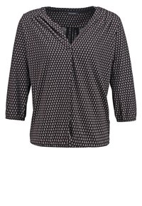 Langärmlige schwarze Bluse mit kleinem beigen geometrischen Muster, V-Ausschnitt und gerafften Manschetten.