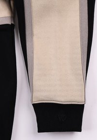 Φούτερ με σχέδιο color-block που περιλαμβάνει μαύρα, μπεζ και γκρι τμήματα. Βαμβακερό ύφασμα, ριμπ μανσέτες και διακριτική λεπτομέρεια λογότυπου.