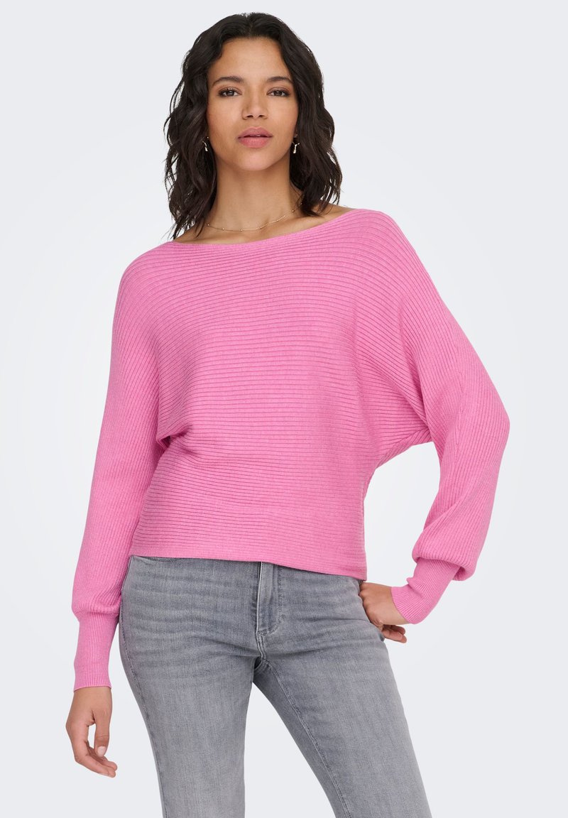 Maglione rosa a coste con ampio scollo a barca e maniche lunghe. Abbinato a jeans grigio chiaro, con vestibilità comoda.