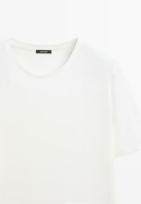 T-shirt blanc à manches courtes avec col rond et étiquette noire Massimo Dutti à l'intérieur du col.