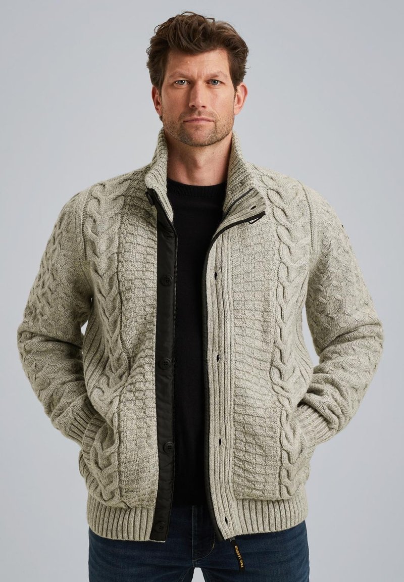 Cardigan a maglia grigia chiara con colletto alto, zip nera a contrasto e polsini a coste. Caratterizzato da motivi testurizzati e chiusura con bottoni.