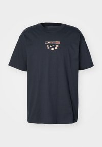 Mørkeblå bomuld t-shirt med rund hals, korte ærmer og et trykt logodesign i lyserød på midten foran.