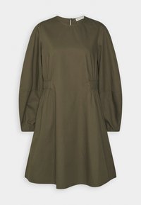 Vestido color verde oliva hecho de algodón, con mangas largas abullonadas, cuello redondo y detalles fruncidos en la cintura. Cierre de ojal en la parte posterior.