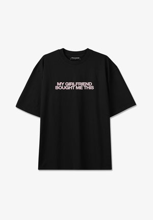 Black short-sleeve T-shirt with pink text "MY GIRLFRIEND BOUGHT ME THIS" centered on the chest, crew neck, loose fit style.