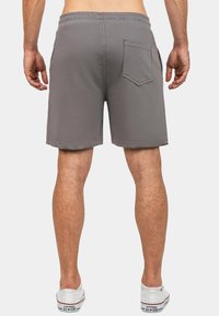 Pantaloni corti grigi realizzati in tessuto leggero, con vita elastica, tasche laterali e una singola tasca posteriore con patta arrotondata.
