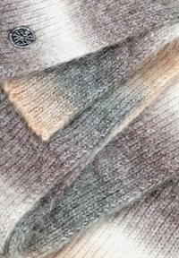 Maglione lavorato a maglia in tonalità sfumate di grigio e beige, caratterizzato da un motivo strutturato e un bottone metallico con motivo circolare.