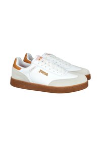 Zapatillas deportivas blancas de corte bajo con acentos marrones, cierre de cordones y la marca "Joma" en el lateral y la lengüeta, sobre un fondo blanco.