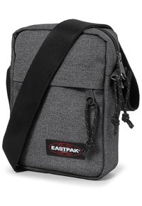 Grå Eastpak skuldertaske med et tekstureret stof, justerbar sort rem, lynlåslommer og et fremtrædende logo på forsiden.