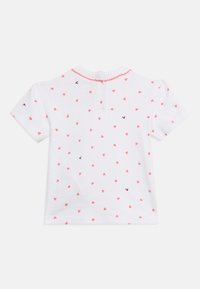 Λευκό βρεφικό μπλουζάκι με κοντά μανίκια, με ρόζ σχέδιο καρδιάς, μικρά κεντημένα πουλιά και ρόζ περίγραμμα με κυματιστό μοτίβο γύρω από το λαιμό.
