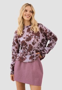 Bloemenpatroon gebreide trui in lichtpaars met bordeauxroze rozen; gecombineerd met een roze gekrulde rok; losse pasvorm en lange mouwen.