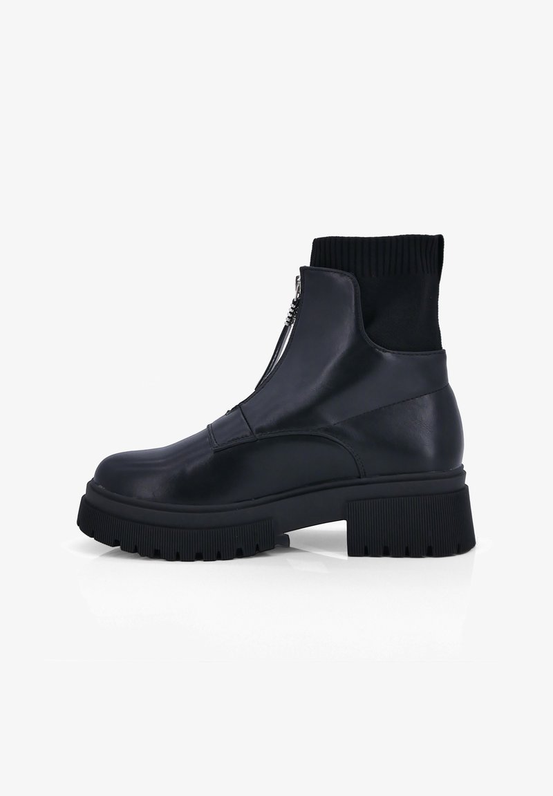 Zwarte enkelboots met een glad leren buitenkant, geribbelde sokkraag en dikke rubberen zool met een gestructureerd grippatroon. Zijritsdetail.