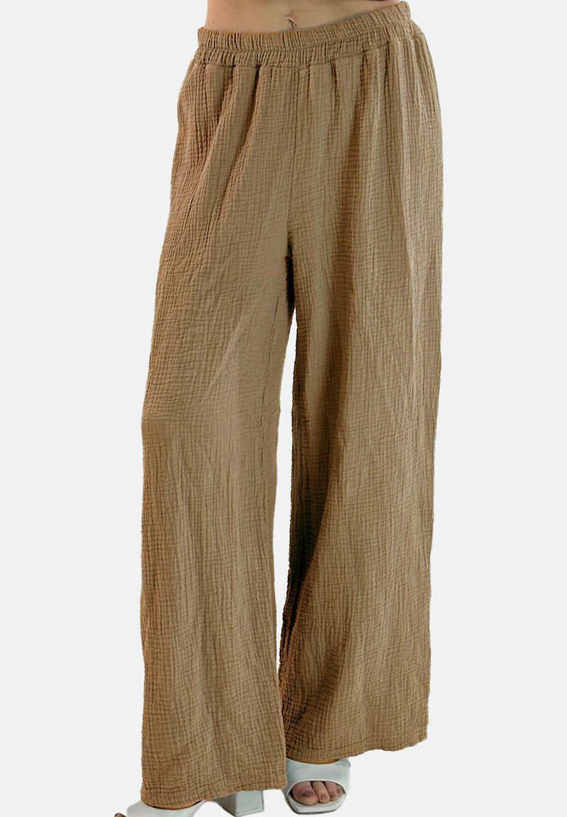 Vide bukser i lysebrun lavet af tekstureret stof med elastisk linning. Har et krøllet mønster og en afslappet pasform.