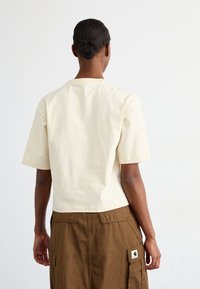 Korte mouw, lichtbeige t-shirt van katoen, met een relaxte pasvorm, ronde halslijn en een naadloos rugontwerp.