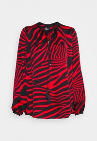 Blouse à manches longues rouge et noire à rayures zèbre, col rond et liens à pompons à l'avant.