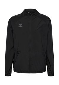 Schwarze, leichte Jacke mit Reißverschluss, seitlichen Taschen und elastischen Bündchen. Mit einem dezenten Logo auf der oberen linken Seite. Glatte Textur.