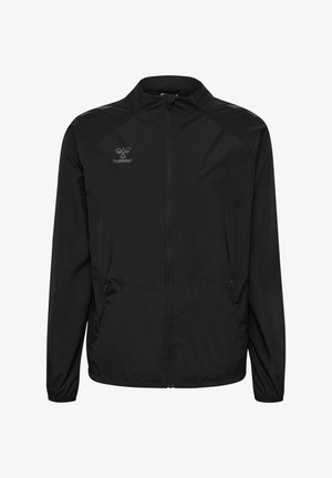 Giacca leggera nera con chiusura a zip, tasche laterali e polsini elastici. Presenta un logo sottile sulla parte superiore sinistra. Texture liscia.