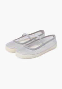 Ballet flats grigie intrecciate con cinturino alla caviglia, superficie texturizzata e suola in gomma. Presentano una palette di colori chiara con una base bianca.