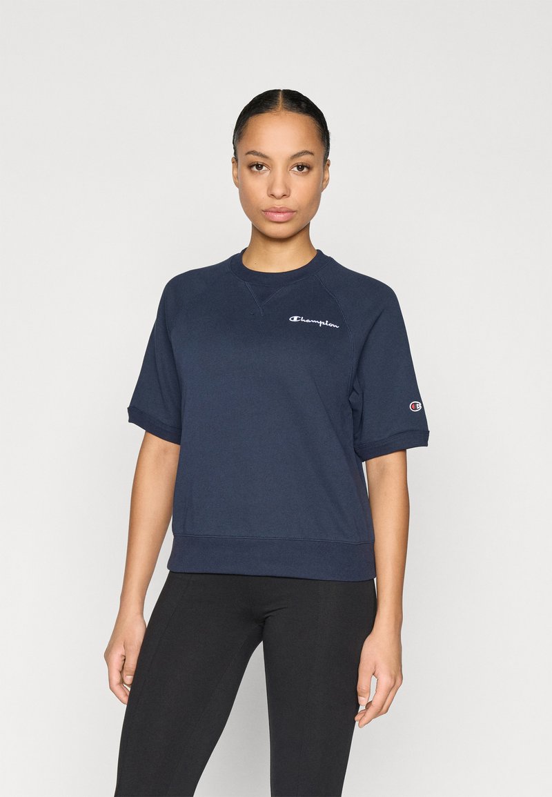 Μπλούζα από βαμβάκι σε ναυτικό μπλε με κοντά μανίκια, ριμπ τελείωμα και λογότυπο στο αριστερό στήθος. Διαθέτει άνετη εφαρμογή και στρογγυλή λαιμόκοψη.