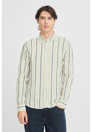Camisa de botones de color claro con rayas verticales en beige y azul marino oscuro. La tela parece ligera y texturizada. Mangas largas con puños.