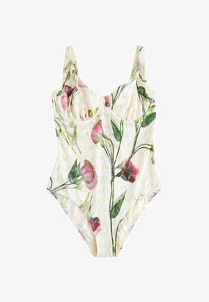 Baltas vientisas maudymosi kostiumėlis su rausvais ir žaliais gėlių raštais bei tekstūruotu zigzago raštu audinyje.