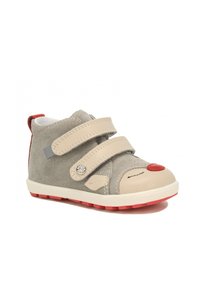 Grijze suède kinderschoen met beige leren accenten, rode hak en klittenbandsluitingen; heeft een speelse neusontwerp op de teen.