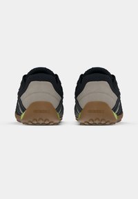 Μαύρα και γκρι αθλητικά παπούτσια με πλέγμα στο πάνω μέρος, μπεζ τακούνι, πράσινες λεπτομέρειες και λαστιχένια σόλα με υφασμένα σημεία πρόσφυσης. Ορατή η μάρκα Geox.