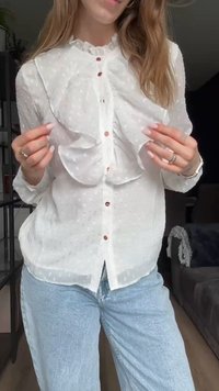 Valkoinen pusero, jossa on röyhelöetut, pistekuviointi ja napit. Yhdistetty vaaleansinisiin farkkuihin. Rennon tyylin, kevyt kangas.