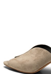 Une mule en daim beige à bout ouvert, talon bas et semelle lisse couleur tan, vue de profil sur fond blanc.
