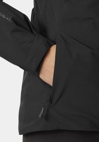 Schwarze wasserdichte Jacke mit hohem Kragen, verstellbarem Bündchen und seitlicher Reißverschlusstasche. Glatte Textur, minimalistisches Design und keine sichtbaren Muster.