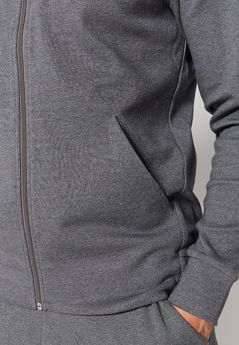 Grijze zip-up hoodie met een gladde, rekbare textuur. Voorzien van zijzakken, geribbelde manchetten en een aansluitende silhouet. Rits loopt van de kraag tot de zoom.