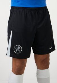Sorte atletiske shorts med kontrasterende lyseblå sidelapper, der har et rundt logo og en sølvfarvet Nike swoosh. Fremstillet af letvægtsstof.