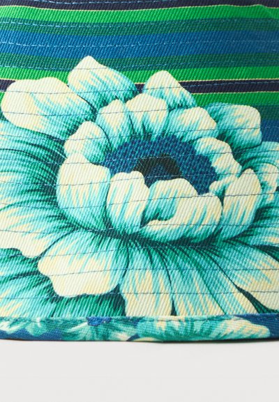 Υφασμάτινο καπιτονέ με μεγάλο σχέδιο πελαγί και εκρού λουλουδιού σε μπλε και πράσινο ριγέ φόντο.