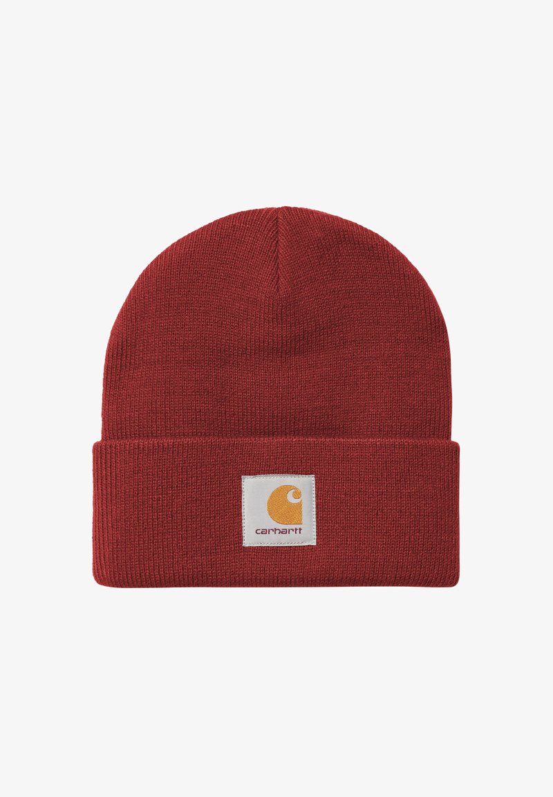 Gorro de punto rojo con dobladillo que presenta un parche rectangular blanco con el logo de Carhartt y un emblema y texto amarillos en el centro frontal.