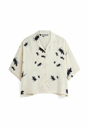 Camisa de manga corta color crema con siluetas de pájaros negros en un patrón disperso, confeccionada en un tejido suave y con frente abotonado.