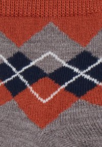Strickpullover mit einem Rautenmuster in Orange, Marineblau und Grau. Glatte Textur mit kontrastierenden weißen Umrandungen der Rauten.