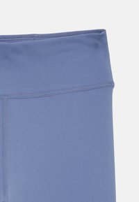 Korkeavyötäröiset legginsit vaaleansinisinä, joissa on sileä pinta ja hieno ompelu. Kangas vaikuttaa joustavalta ja mukavalta.