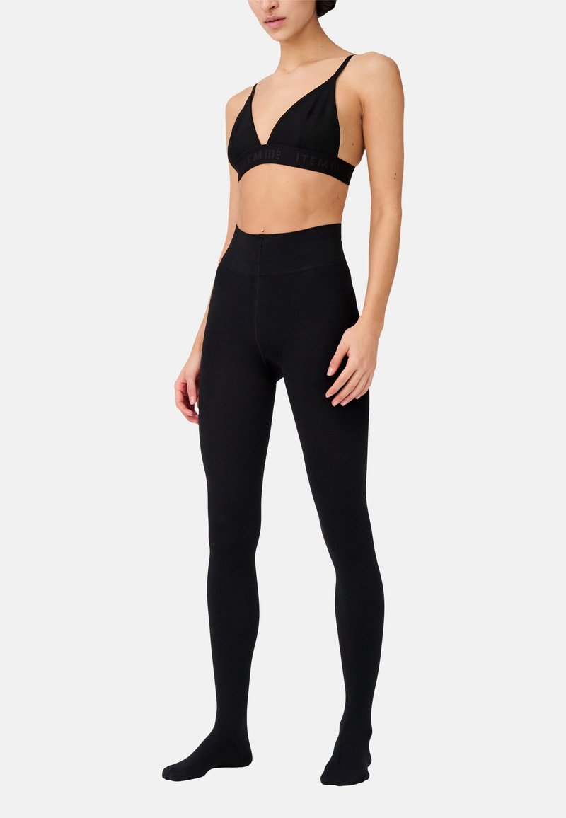 Leggings neri senza cuciture e un bralette coordinato con scollatura a V profonda e cintura con logo, entrambi realizzati in materiale elastico.