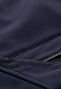 Marineblauer Stoff mit glatter Textur und kontrastierenden Nahtstickereien. Das Design zeichnet sich durch überlappende Bereiche und flache Akzente aus.