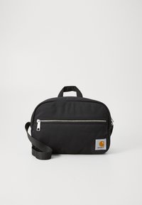 Borsa in tessuto nero con chiusura a cerniera, tasca frontale, tracolla regolabile e una piccola etichetta arancione sul lato.