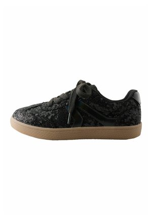 Black low-top sneaker with black laces, sequined fabric upper, glossy black side detail, and a light brown textured sole.