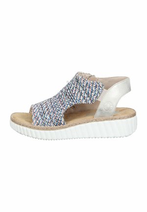 Open-toe women's sandal with multicolored woven upper, beige cushioned footbed, silver heel strap, and thick white ridged sole.